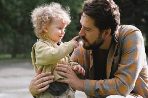 A Tulsa father smiling with his young child, researching how long does a father have to sign a birth certificate in Oklahoma.